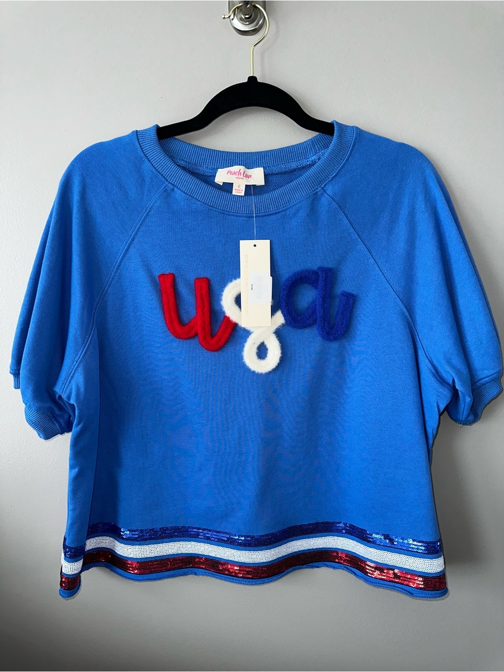 Cute relaxed fit knit blue with USA on front. Sequins around trim. Tags still on